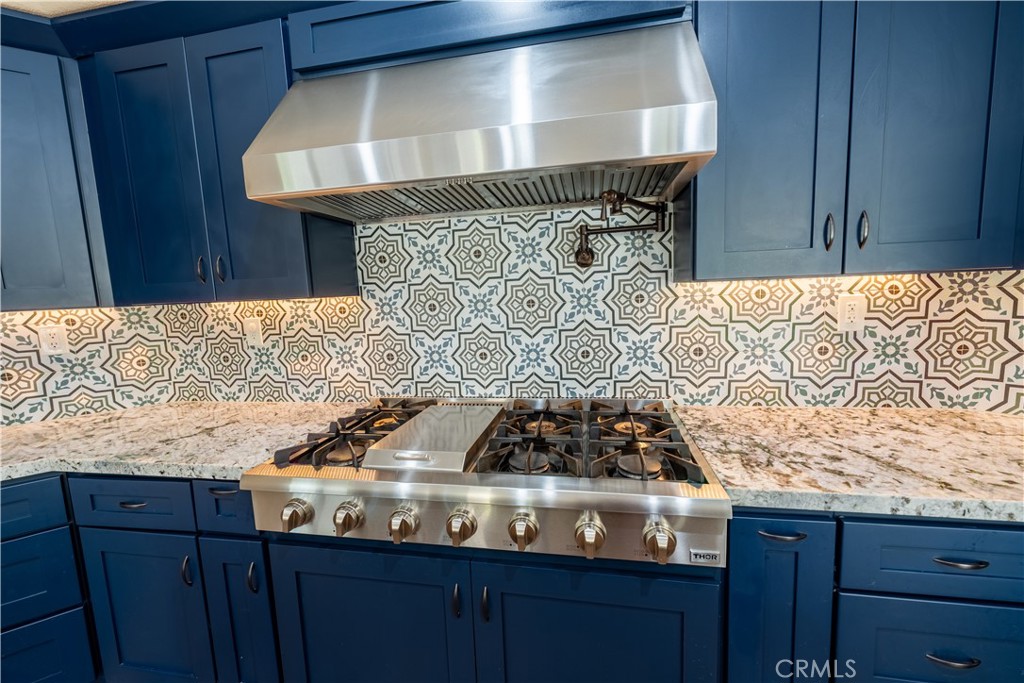 31465 Inverness Court Temecula, CA 92591 - Photo 41 of 71 a room with granite countertop a stove and a wooden chair