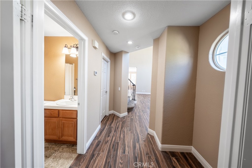 31465 Inverness Court Temecula, CA 92591 - Photo 46 of 71 a view of a hallway with wooden floor and a bathroom
