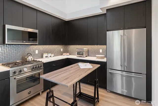 a kitchen with a stove a refrigerator and a microwave