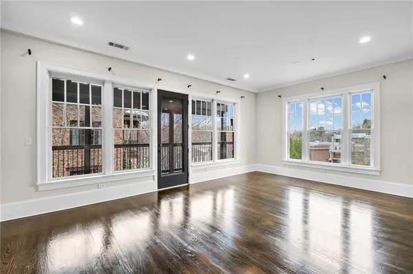 a large kitchen with a center island wooden floor stainless steel appliances and cabinets