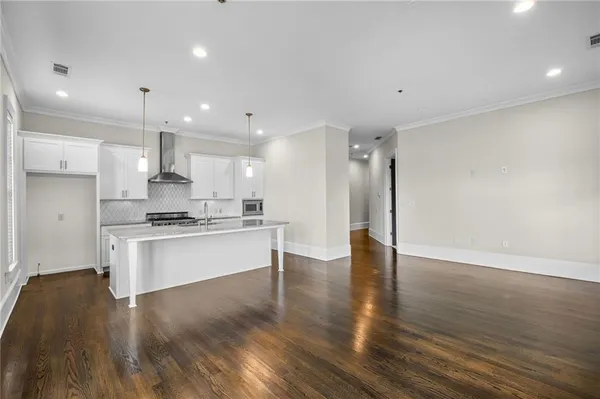 a kitchen with stainless steel appliances granite countertop a sink and wooden floor