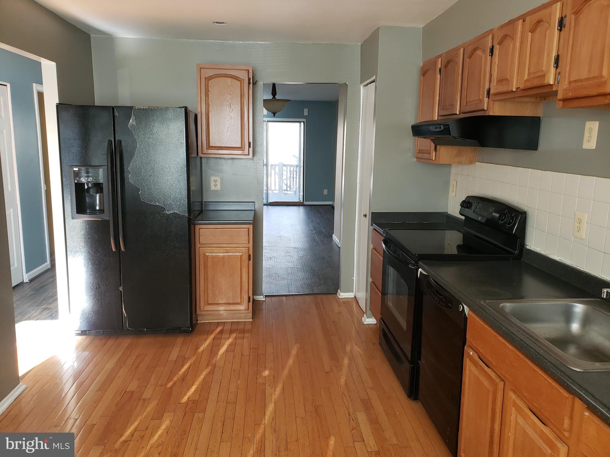 4 Mainview Court Randallstown, MD 21133 - Photo 5 of 25 a kitchen with stainless steel appliances granite countertop a refrigerator a stove and a sink with wooden cabinets