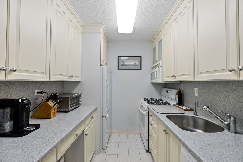 9 Hawthorne Place, Unit 14N Boston, MA 02114 - Photo 12 of 15 a kitchen with white cabinets and sink
