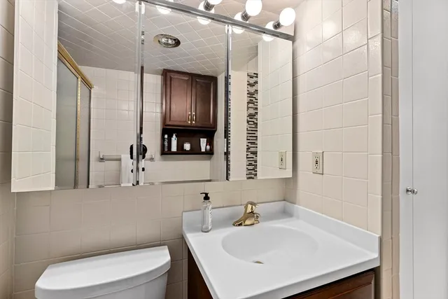 a bathroom with a sink a toilet and mirror