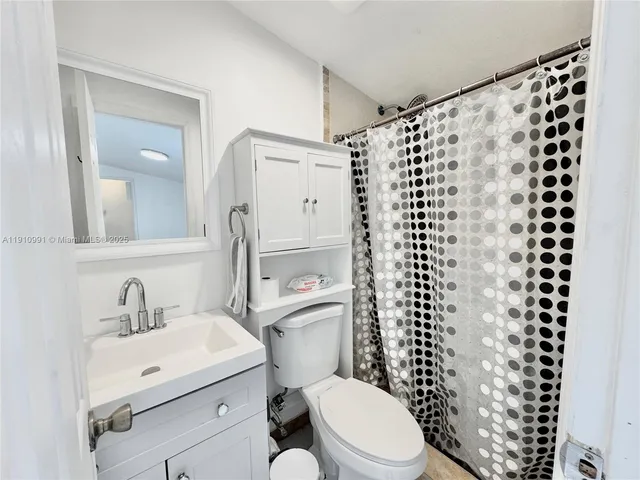 a bathroom with a sink a toilet a shower and a mirror