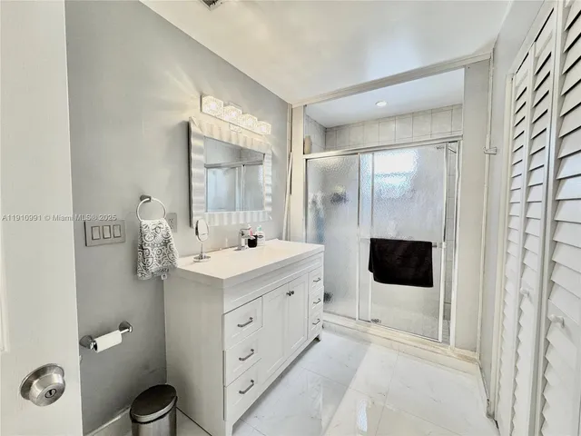 a spacious bathroom with a granite countertop sink and a mirror