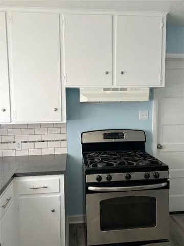 a stove top oven sitting inside of a kitchen