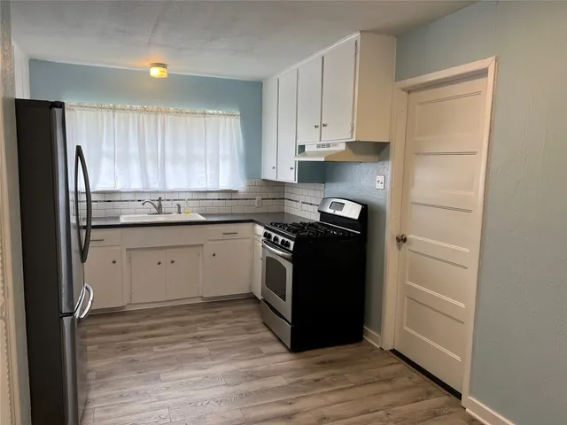a kitchen with a sink stove and refrigerator