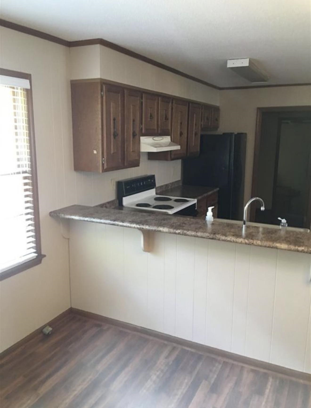 73 Hughes Drive Jackson, TN 38305 - Photo 4 of 24 a kitchen with stainless steel appliances granite countertop a sink a stove and a wooden floors