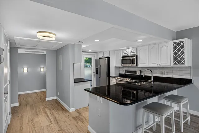 a view of a lake with a house and a couple of people sitting on deck