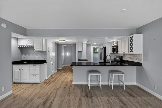 a kitchen with granite countertop white cabinets and stainless steel appliances