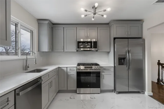 a kitchen with stainless steel appliances granite countertop a stove a sink and a refrigerator