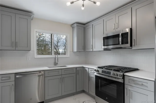 a kitchen with cabinets appliances a sink and a window