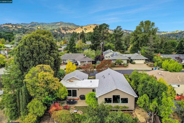 a aerial view of a house with a big yard and large trees