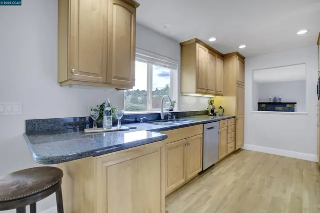 a kitchen with stainless steel appliances granite countertop a sink and a stove