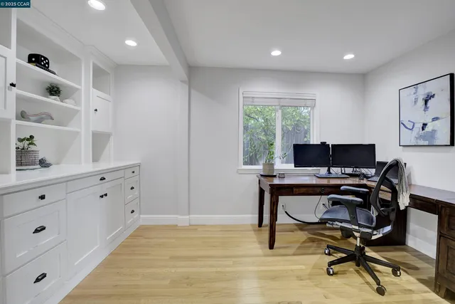 a view of a workspace with furniture and a window