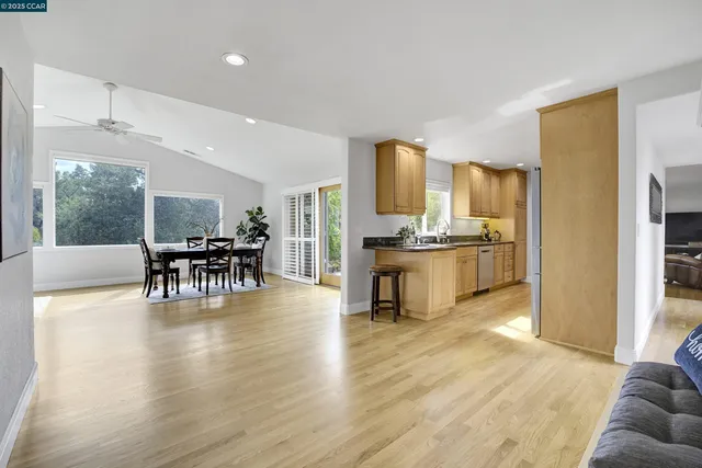 a kitchen with stainless steel appliances a dining table chairs and a refrigerator