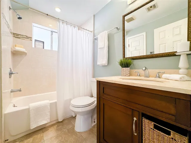 a bathroom with a sink a toilet a mirror and shower