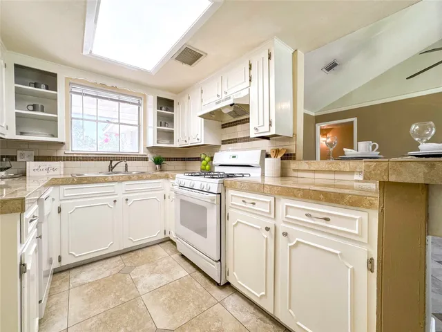 a kitchen with granite countertop white cabinets and white appliances