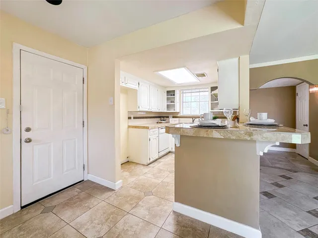 a kitchen with kitchen island granite countertop a sink cabinets and stainless steel appliances
