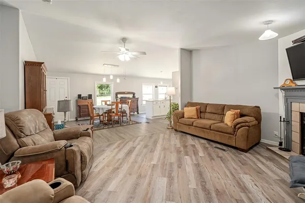 a living room with furniture a fireplace and a flat screen tv
