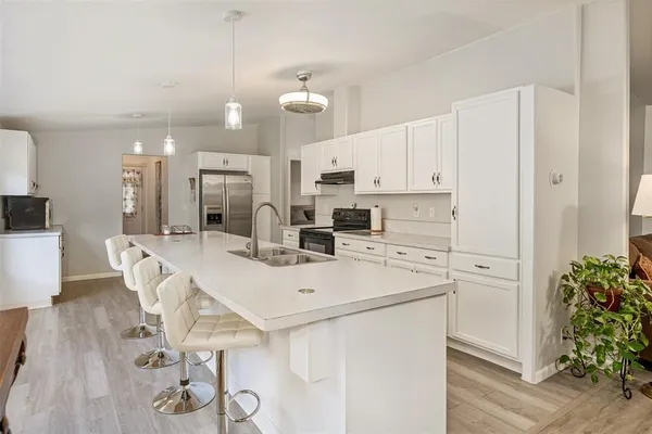 a kitchen with kitchen island a stove a table and chairs
