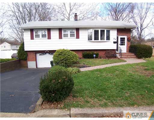 54 Oxford Road Colonia, NJ 07067 - Photo 1 of 18 a front view of a house with a yard and garage