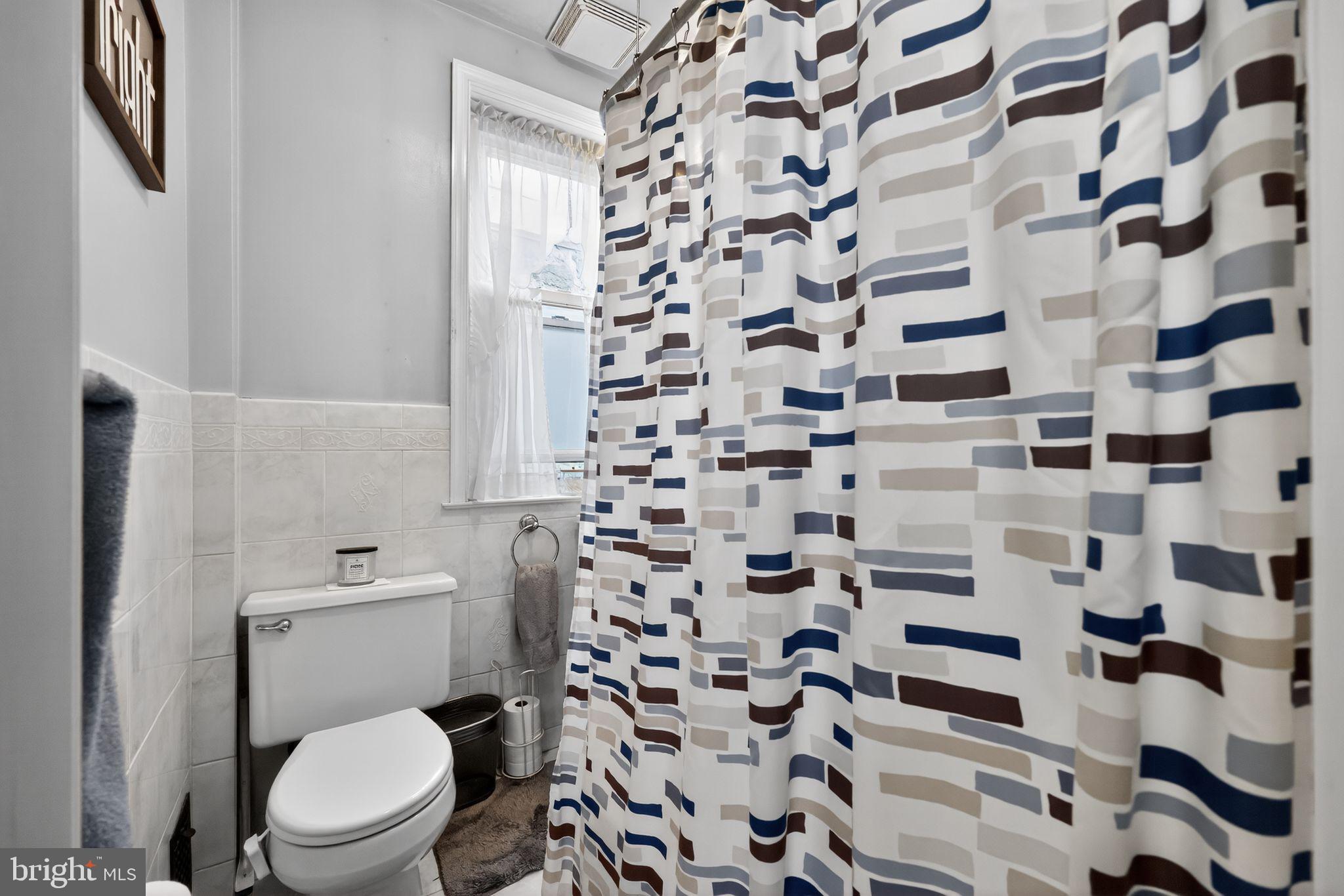 3067 Cedar Street Philadelphia, PA 19134 - Photo 19 of 30 a white toilet sitting next to a shower curtain