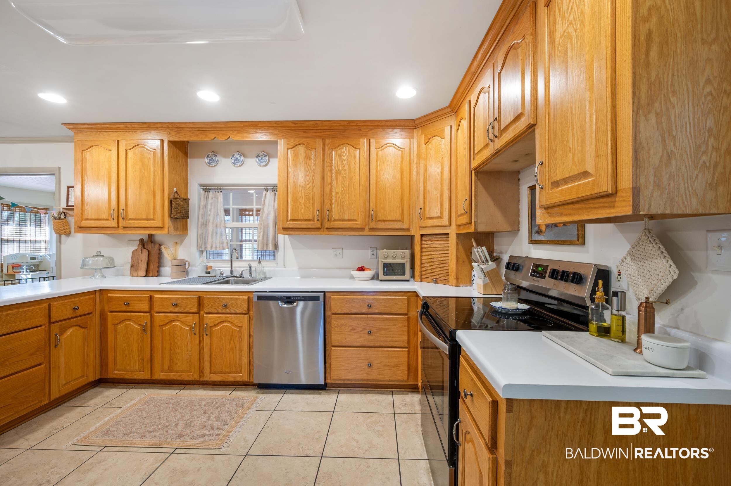 809 Moog Avenue Bay Minette, AL 36507 - Photo 11 of 33 Kitchen featuring stainless steel appliances, light countertops, wood finish cabinets, recessed lighting, and light tile patterned floors