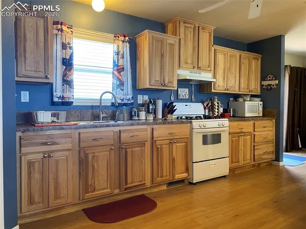 a kitchen with granite countertop wooden floors and white cabinets