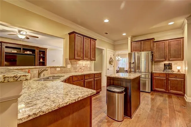 a kitchen with kitchen island granite countertop a sink stove and refrigerator