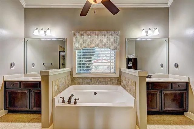 a bathroom with a tub a sink and a large mirror