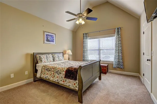 a bed room with a bed and a ceiling fan