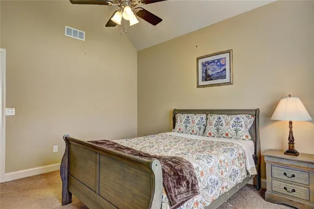 a bedroom with a bed and a lamp on dresser