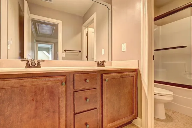 a bathroom with a double vanity sink toilet and a tub