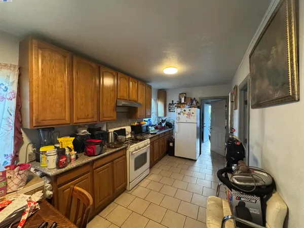 a kitchen with stainless steel appliances granite countertop a refrigerator and a stove top oven