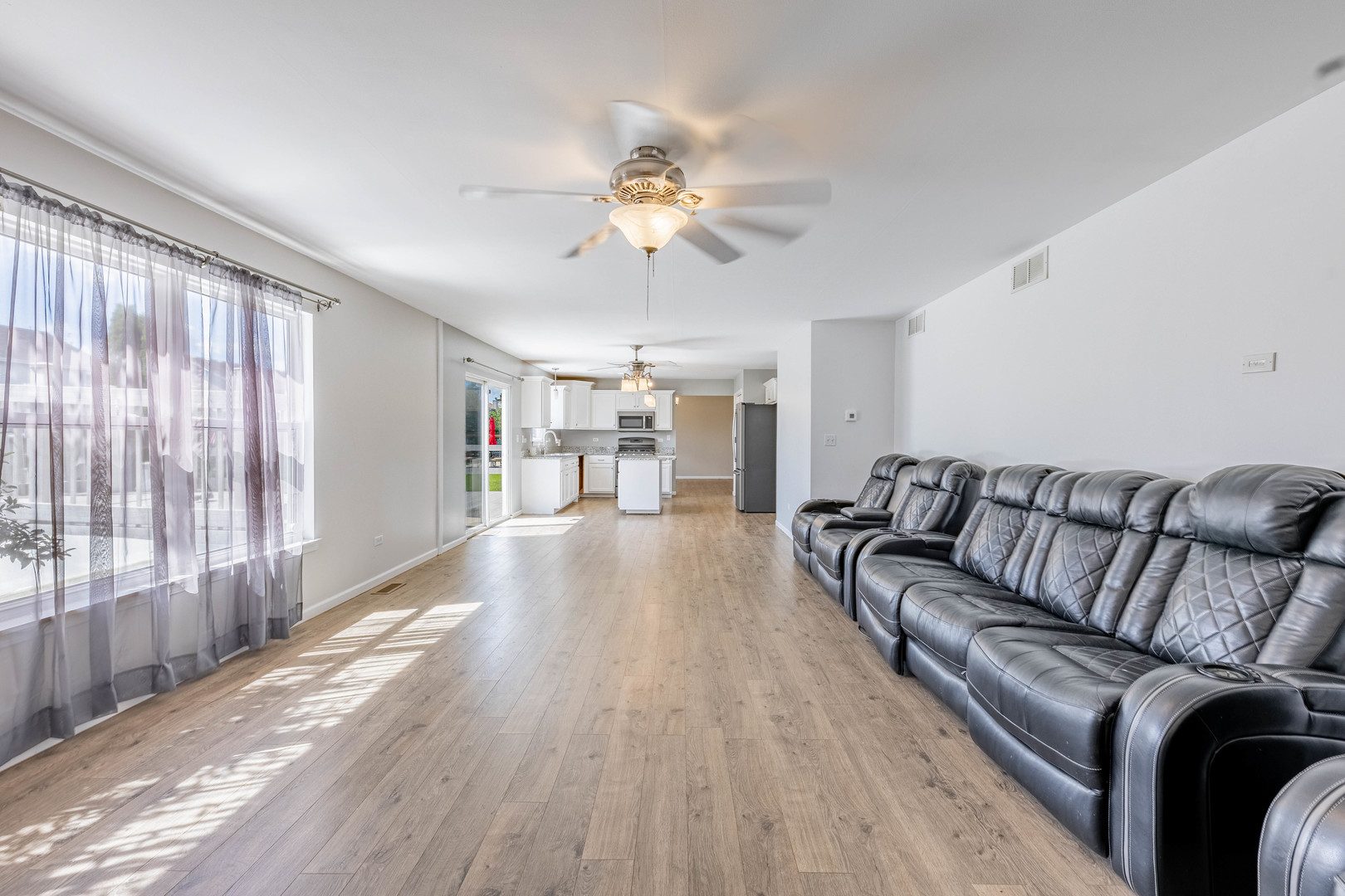 16263 Celtic Circle Manhattan, IL 60442 - Photo 17 of 45 a living room with furniture and a large window with wooden floor