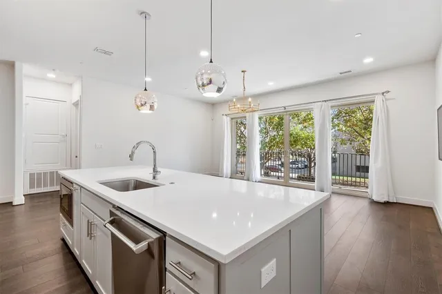 a kitchen that has a sink a stove and a wooden floor