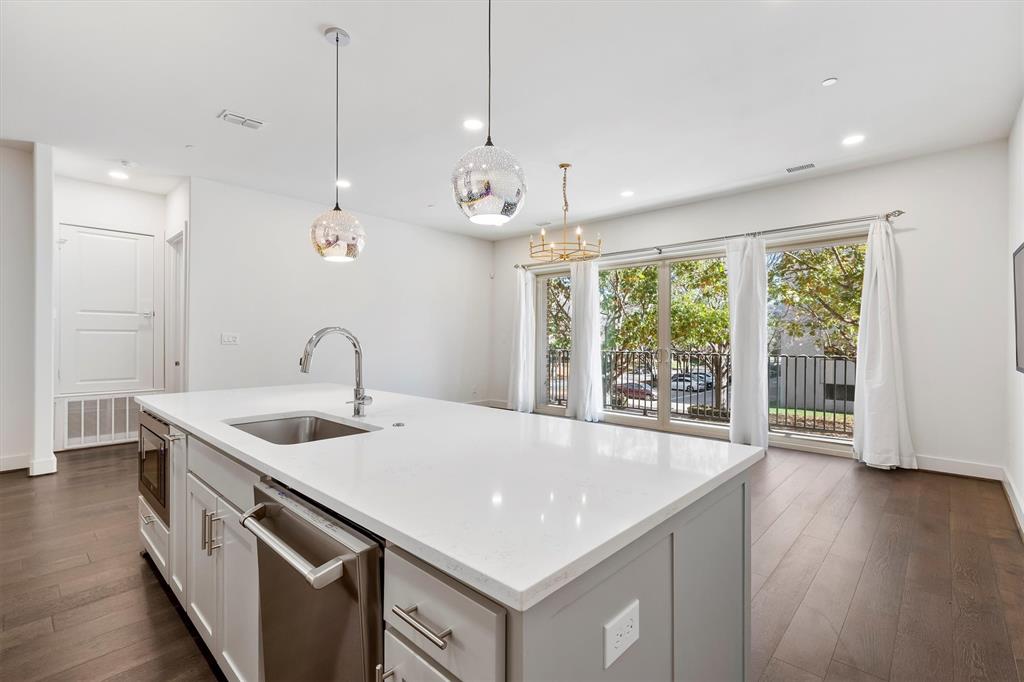 15875 Spectrum Drive, Unit 1106 Addison, TX 75001 - Photo 12 of 39 a kitchen with stainless steel appliances granite countertop a sink a oven and wooden floor