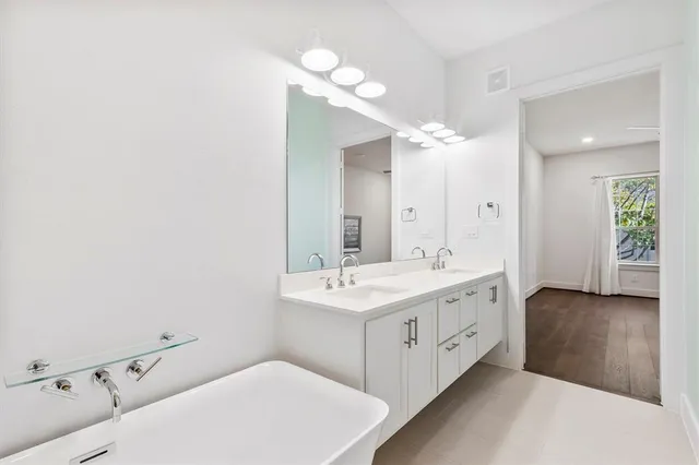 a bathroom with a double vanity sink mirror and toilet