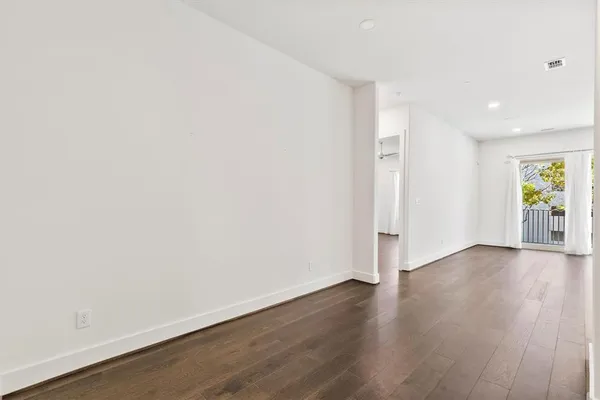 a view of a hallway with wooden floor windows and a bathroom