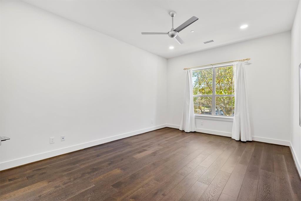15875 Spectrum Drive, Unit 1106 Addison, TX 75001 - Photo 7 of 39 an empty room with wooden floor fan and windows