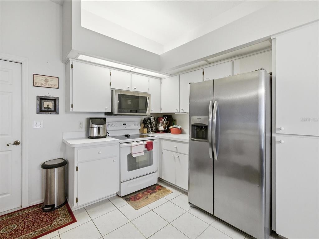 4209 Avanti Circle New Port Richey, FL 34655 - Photo 15 of 35 a kitchen with a refrigerator a stove top oven a sink and dishwasher