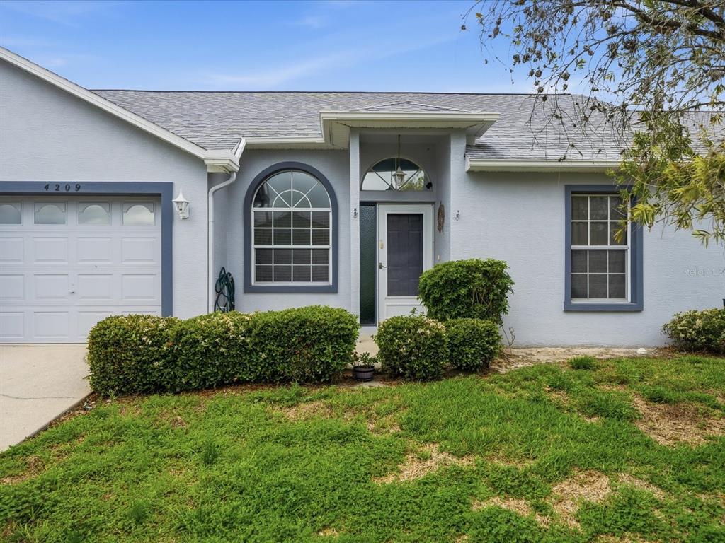 4209 Avanti Circle New Port Richey, FL 34655 - Photo 2 of 35 a front view of a house with garden