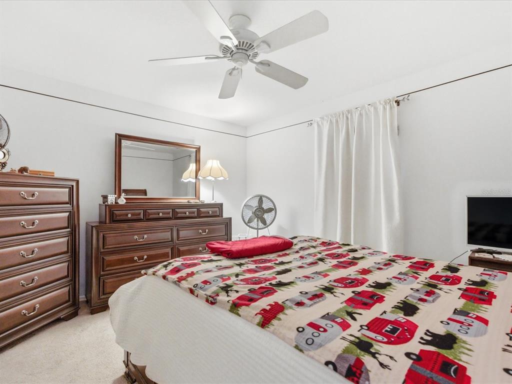 4209 Avanti Circle New Port Richey, FL 34655 - Photo 26 of 35 a bedroom with a bed and a tv on a dresser