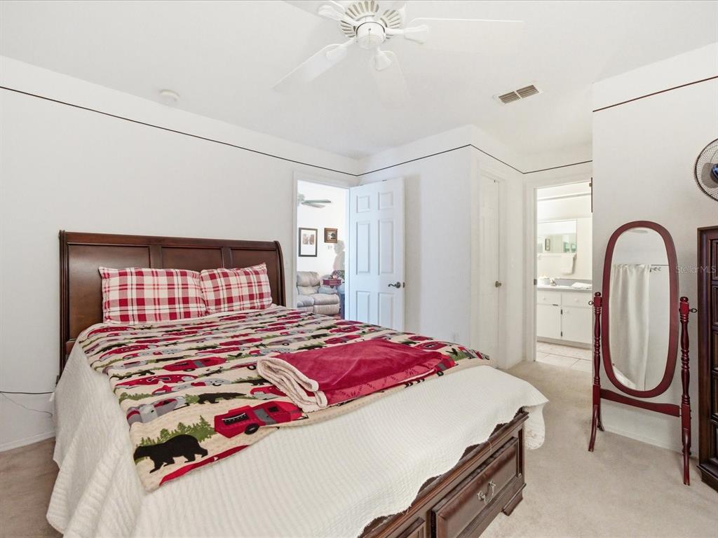4209 Avanti Circle New Port Richey, FL 34655 - Photo 28 of 35 a bedroom with a bed and a chandelier