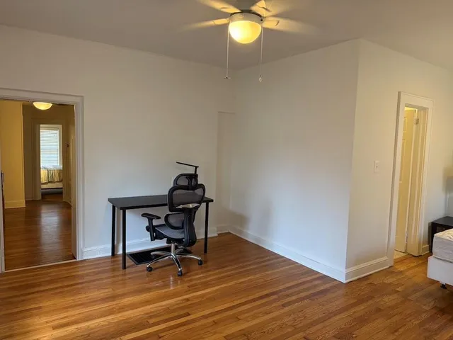 a view of a room with wooden floor and furniture