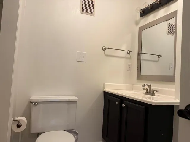 a bathroom with a sink a toilet and mirror