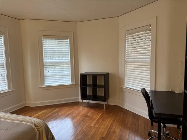 a view of a bedroom with wooden floor and a window