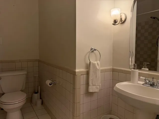 a bathroom with a toilet sink and mirror